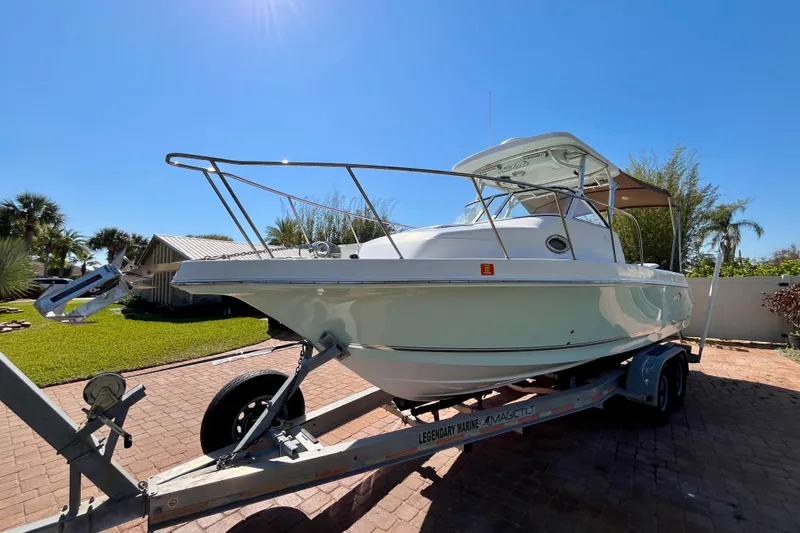 Slide: The Image of 2018 Pro-Line 26 Express boat on trailer, parked on brick driveway under clear blue sky. - 7