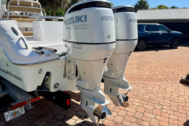 Slide: The Image of 2018 Pro-Line 26 Express boat with twin Suzuki 225 outboard engines on a brick driveway. - 8