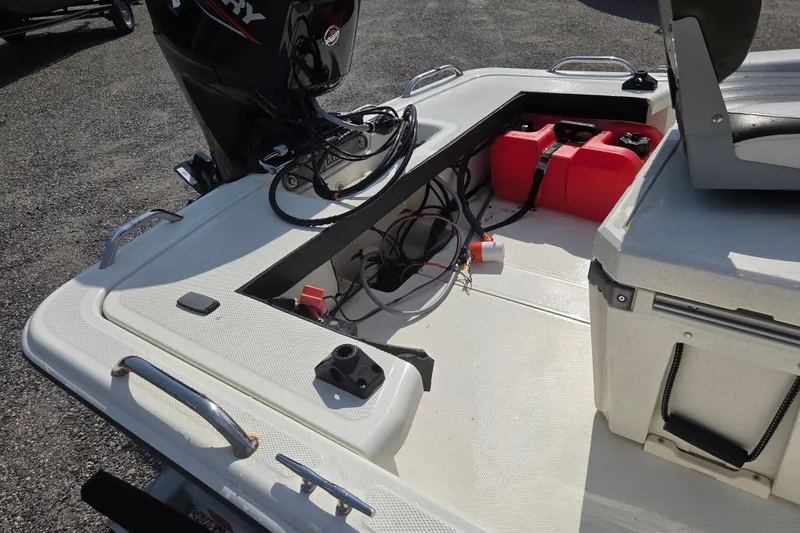 Slide: The Image of 2021 Mako Pro Skiff 15 CC boat interior with motor and storage compartments. - 10