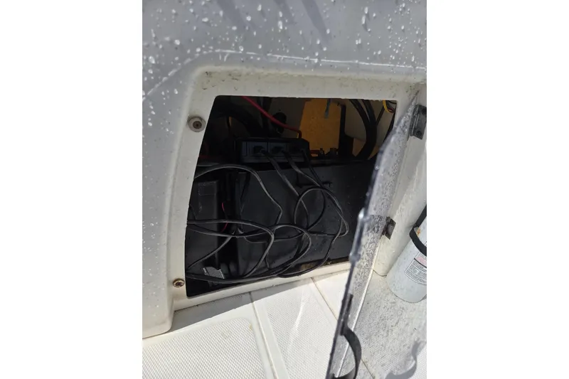 Slide: The Image of 2021 Mako Pro Skiff 15 CC battery compartment with wiring and open hatch. - 13