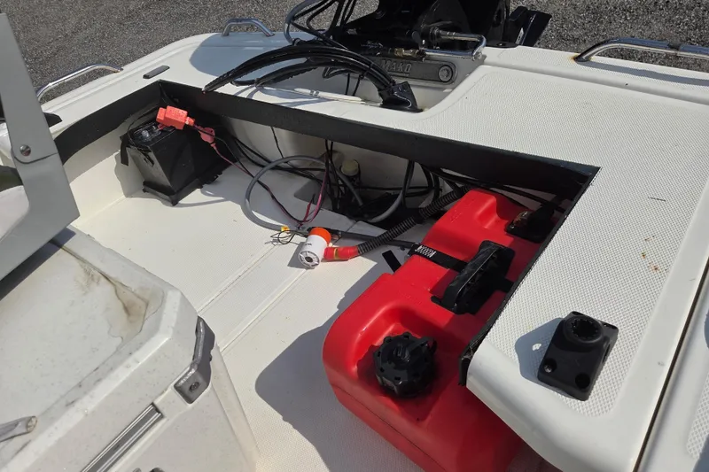 Slide: The Image of 2021 Mako Pro Skiff 15 CC boat interior showing fuel tank and battery setup. - 15
