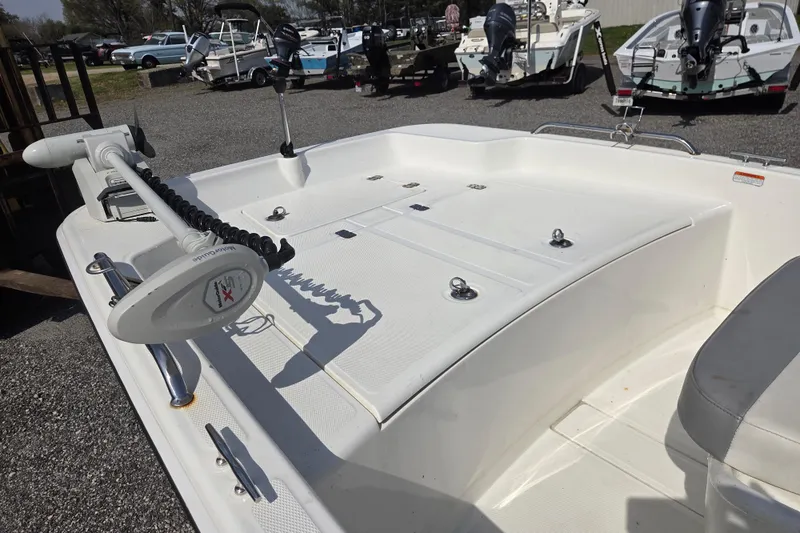 Slide: The Image of 2021 Mako Pro Skiff 15 CC boat deck with trolling motor, parked among other boats. - 19