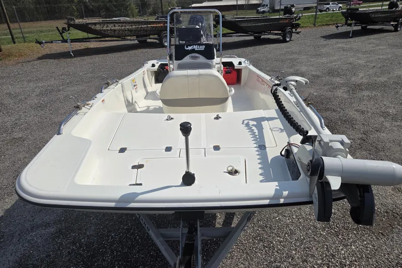 Slide: The Image of 2021 Mako Pro Skiff 15 CC boat, white deck, parked on gravel lot. - 2