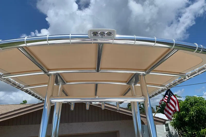 Slide: The Image of 2020 Tidewater 1910 Bay Max boat T-top with American flag in background. - 13