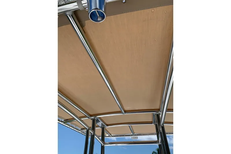 Slide: The Image of Tidewater 1910 Bay Max 2020 boat canopy with metal frame under clear sky. - 14