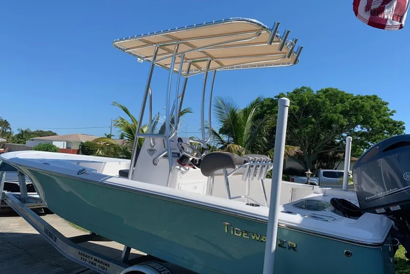 Slide: The Image of 2020 Tidewater 1910 Bay Max boat with T-top, parked on trailer, sunny day. - 2