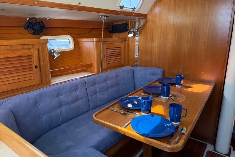 Slide: The Image of Cozy dining area in a 1995 Catalina 36 MkII sailboat with blue seating and tableware. - 11