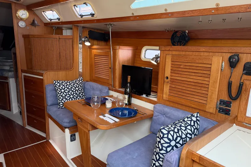 Slide: The Image of Interior of 1995 Catalina 36 MkII sailboat with cozy dining area and wooden cabinetry. - 13