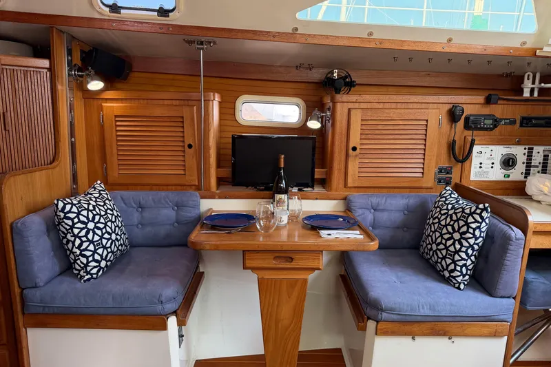 Slide: The Image of Cozy dining area in a 1995 Catalina 36 MkII sailboat with blue cushions and wooden accents. - 14