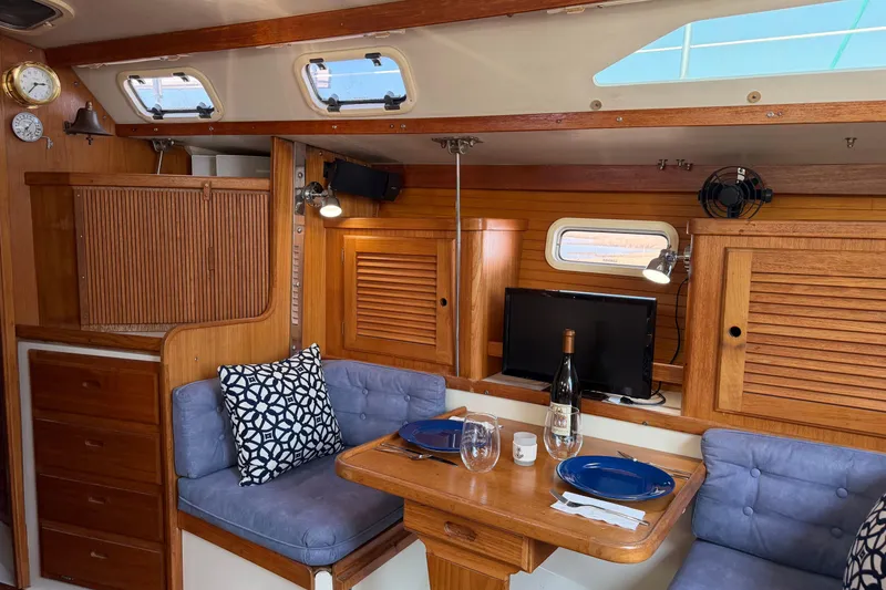 Slide: The Image of Interior of a 1995 Catalina 36 MkII sailboat with cozy dining area and wooden cabinetry. - 15