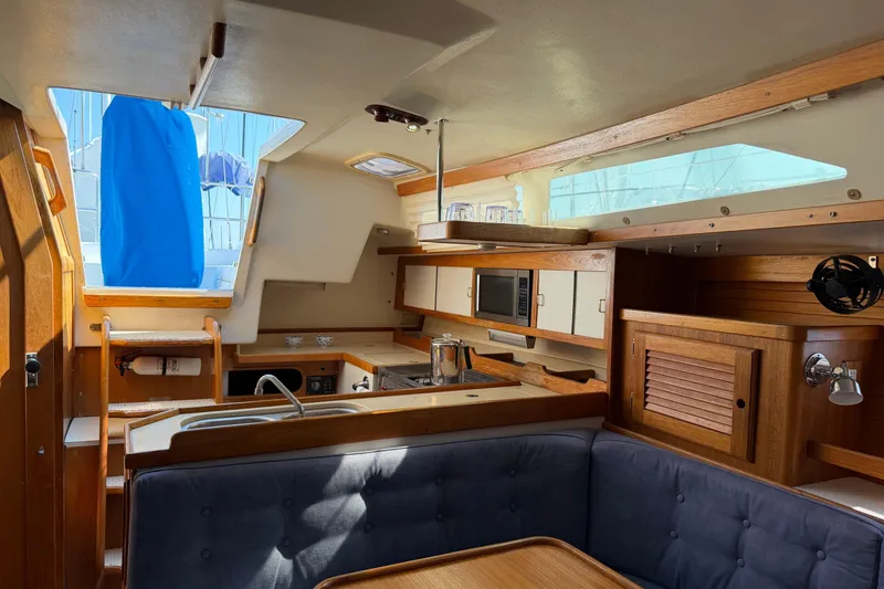 Slide: The Image of Interior of a 1995 Catalina 36 MkII sailboat, featuring a cozy kitchen and dining area. - 16