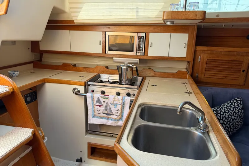 Slide: The Image of Interior of 1995 Catalina 36 MkII yacht kitchen with stove, sink, and wooden cabinetry. - 20