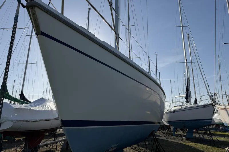 Slide: The Image of 1995 Catalina 36 MkII sailboat on dry dock, surrounded by other vessels. - 3