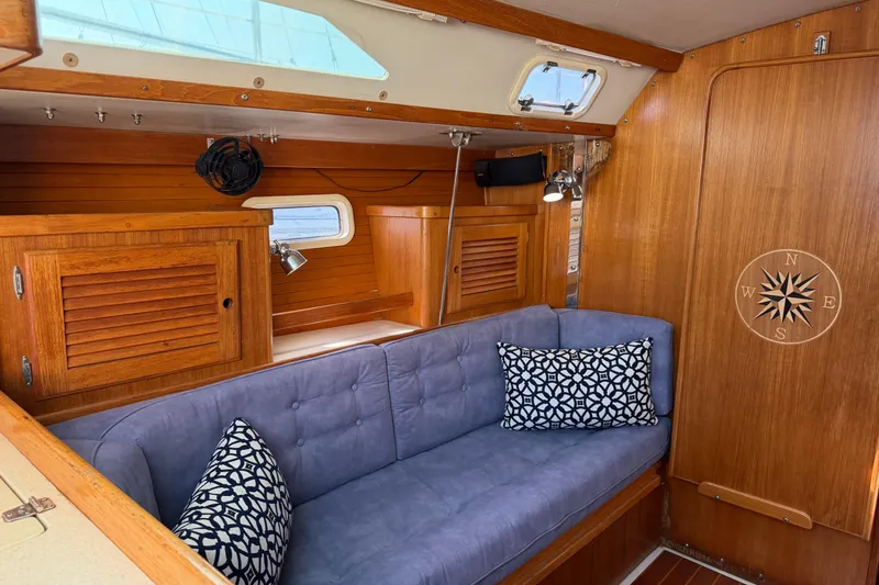 Slide: The Image of Interior of a 1995 Catalina 36 MkII sailboat with wooden cabinetry and blue cushioned seating. - 8