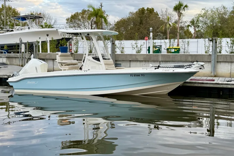Slide: The Image of 2022 Boston Whaler 220 Dauntless boat docked in a marina setting. - 14