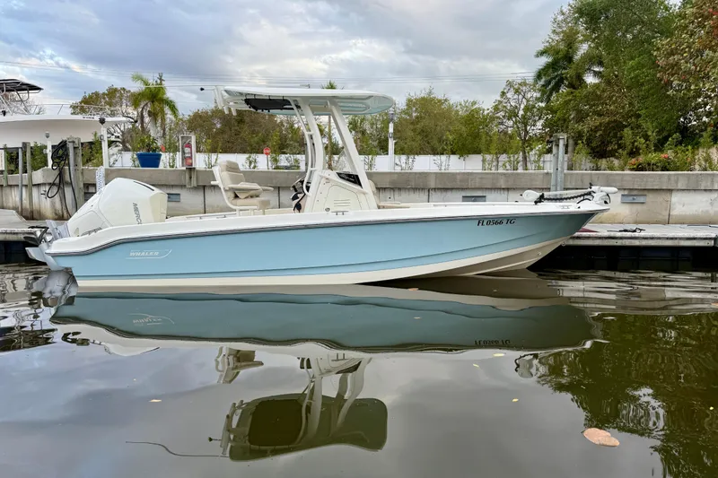 Slide: The Image of 2022 Boston Whaler 220 Dauntless boat docked on calm water, side view. - 15