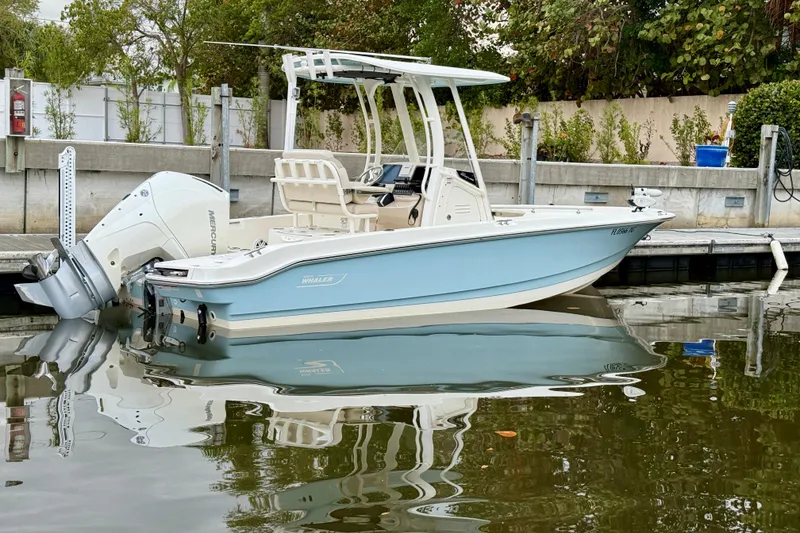 Slide: The Image of 2022 Boston Whaler 220 Dauntless boat docked, featuring sleek design and powerful Mercury engine. - 17
