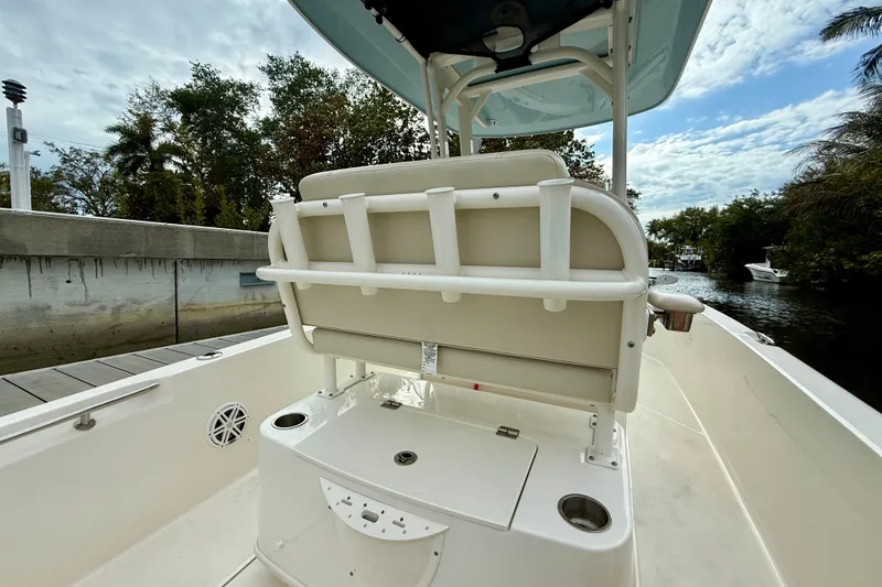 Slide: The Image of 2022 Boston Whaler 220 Dauntless boat interior with seating and storage, docked by a canal. - 21