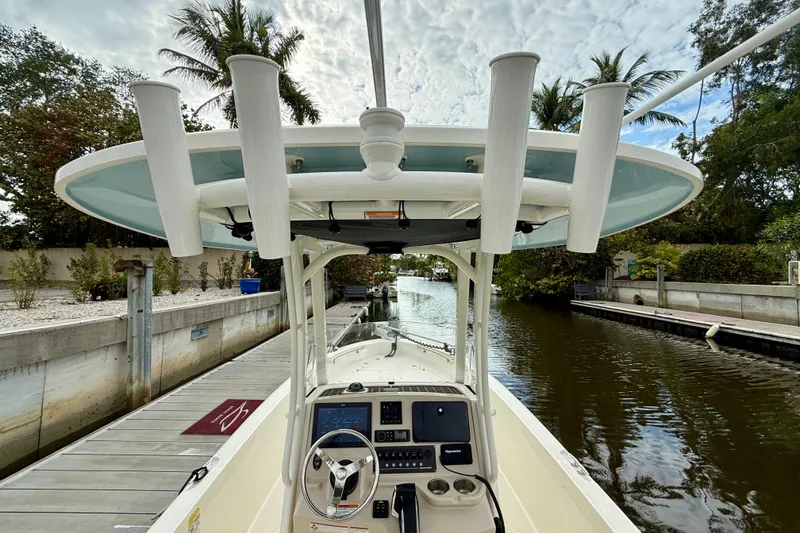 Slide: The Image of 2022 Boston Whaler 220 Dauntless boat docked on a serene canal with lush greenery. - 23