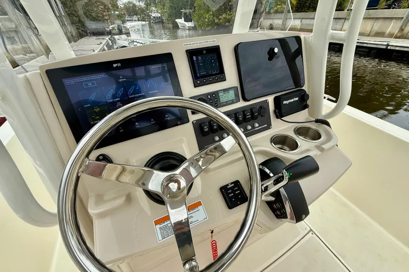 Slide: The Image of Boston Whaler 220 Dauntless 2022 boat dashboard with steering wheel and navigation controls. - 26