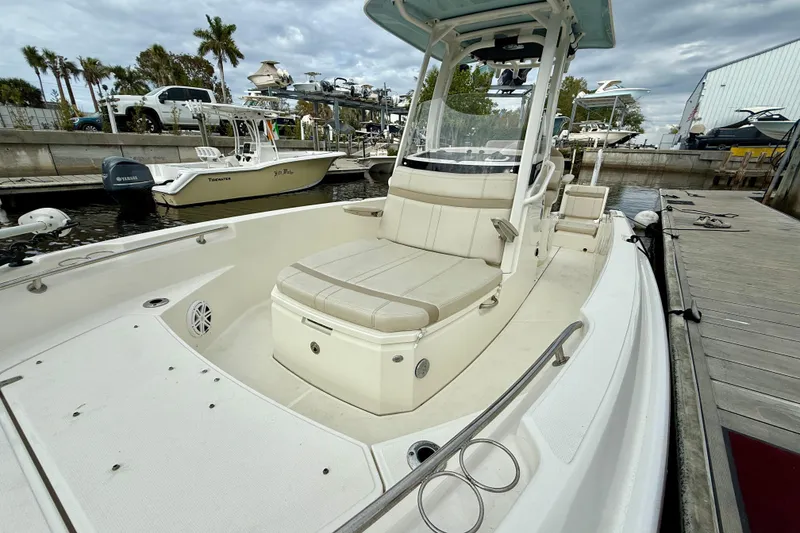 Slide: The Image of 2022 Boston Whaler 220 Dauntless boat docked, featuring spacious seating and sleek design. - 27