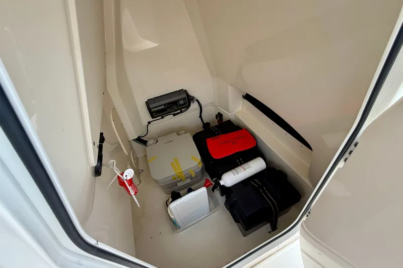 Slide: The Image of Interior storage of 2022 Boston Whaler 220 Dauntless with emergency kit and equipment. - 31