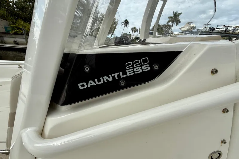 Slide: The Image of 2022 Boston Whaler 220 Dauntless boat detail with logo and sleek design. - 32