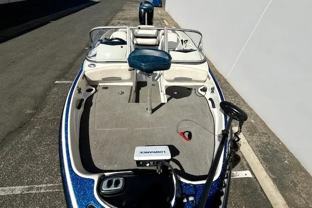 Slide: The Image of 2016 Nitro Z-7 Sport boat with seating and fishing equipment, parked on pavement. - 4