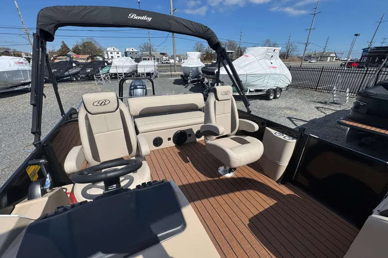 Slide: The Image of 2026 Bentley Pontoons Legacy 243 Swingback interior with beige seating and wood flooring. - 13
