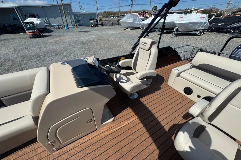 Slide: The Image of 2026 Bentley Pontoons Legacy 243 Swingback interior with beige seating and steering console. - 14