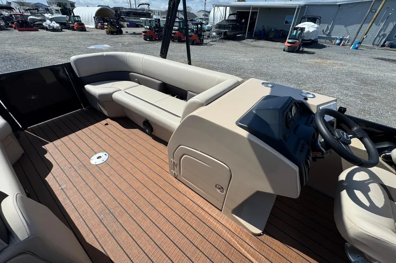 Slide: The Image of 2026 Bentley Pontoons Legacy 243 Swingback interior with beige seating and wooden deck. - 16