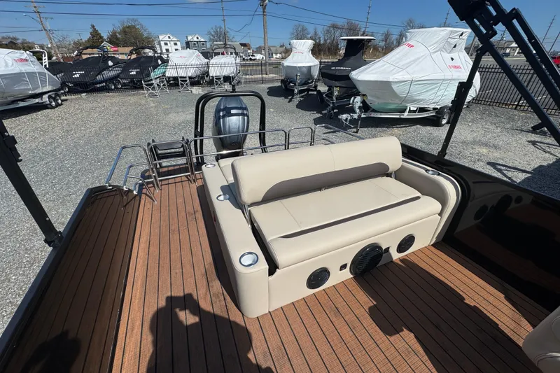 Slide: The Image of 2026 Bentley Pontoons Legacy 243 Swingback with beige seating and wood deck in a boatyard. - 19