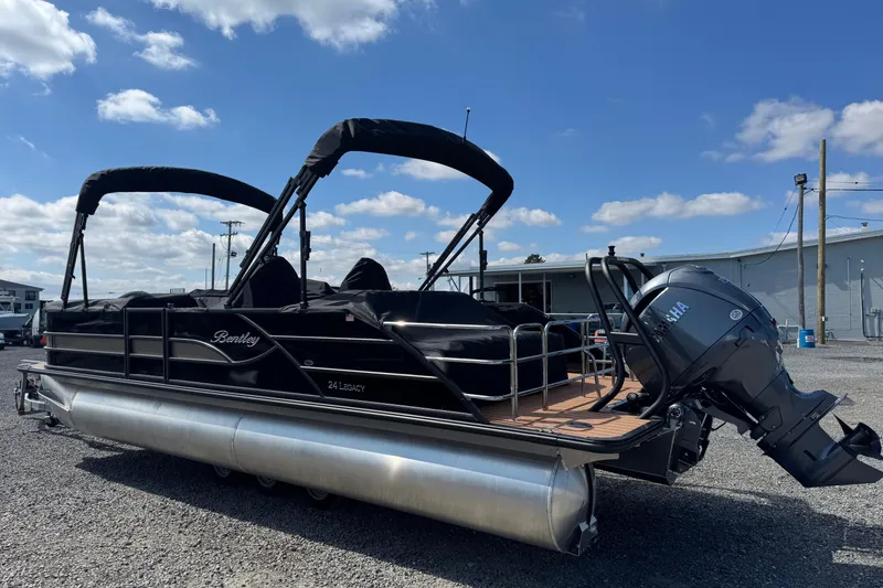 Slide: The Image of 2026 Bentley Pontoons Legacy 243 Swingback with Yamaha engine, parked outdoors under blue sky. - 7