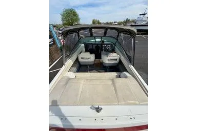 Slide: The Image of 1989 Cobalt Condurre 243 boat with open cockpit and seating, parked outdoors. - 3