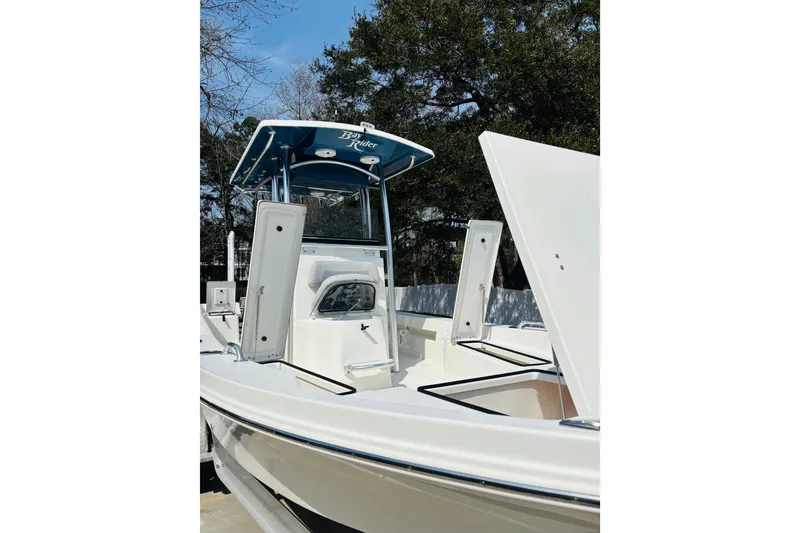 Slide: The Image of 2022 Bay Rider 239 Bay boat with open storage compartments, featuring a sleek design. - 14