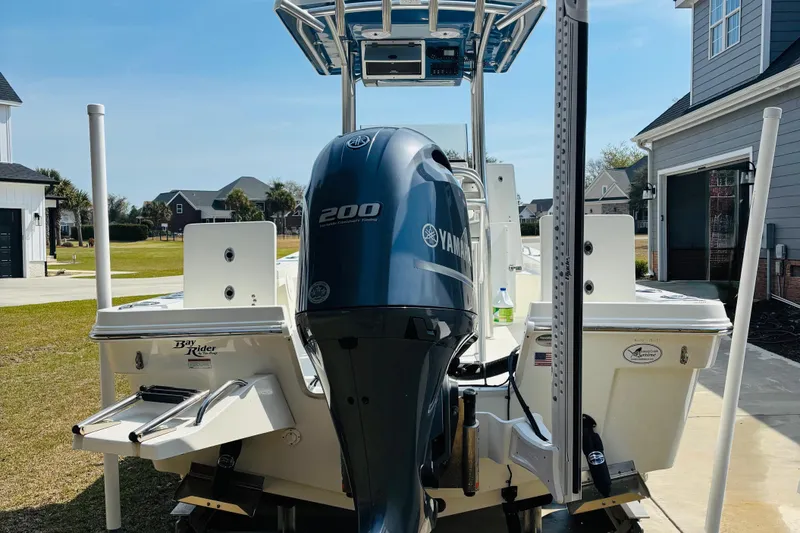 Slide: The Image of 2022 Bay Rider 239 Bay boat with Yamaha 200 engine, parked in a residential driveway. - 18