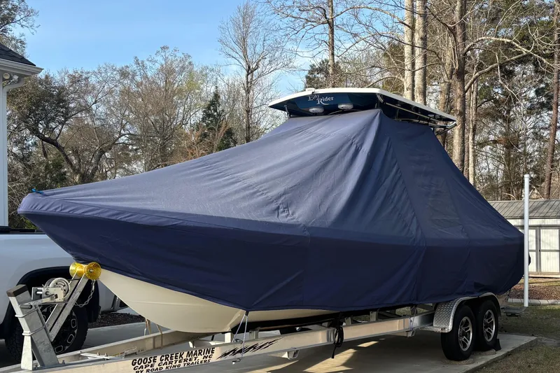 Slide: The Image of 2022 Bay Rider 239 Bay boat covered on trailer, parked outdoors. - 19