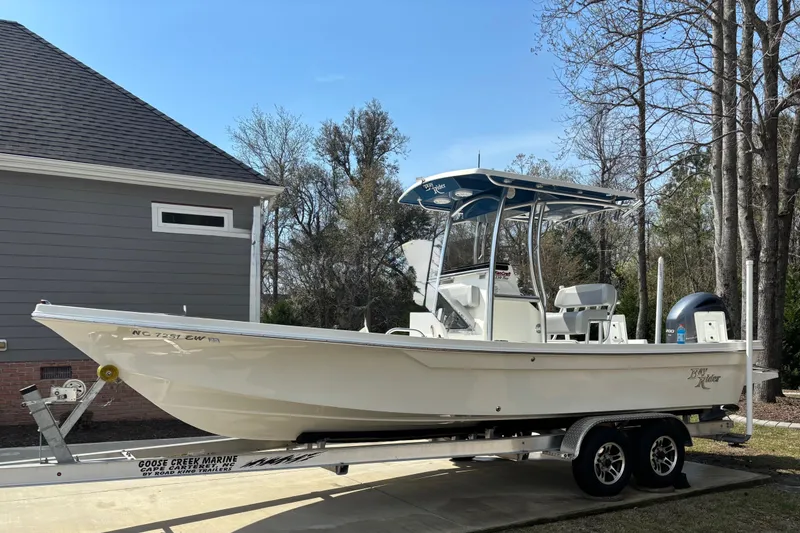 The Image of 2022 Bay Rider 239 Bay boat on trailer, parked beside a house. - 9