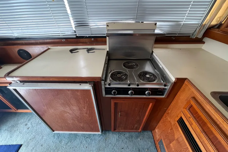 Slide: The Image of 1989 Egg Harbor 35 Sport Fisherman kitchen with stove and wooden cabinetry. - 16
