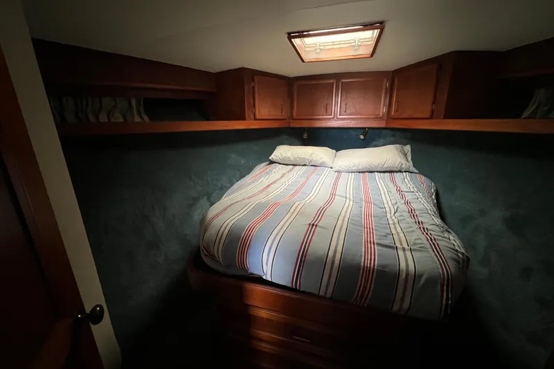 Slide: The Image of Cozy cabin bedroom in 1989 Egg Harbor 35 Sport Fisherman boat with striped bedding. - 18