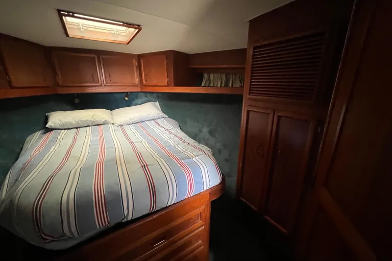 Slide: The Image of Cozy cabin interior of 1989 Egg Harbor 35 Sport Fisherman with striped bedding. - 19