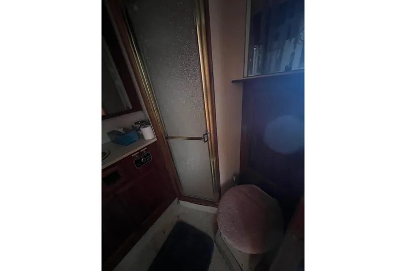 Slide: The Image of Interior of 1989 Egg Harbor 35 Sport Fisherman, featuring a compact bathroom with shower. - 23