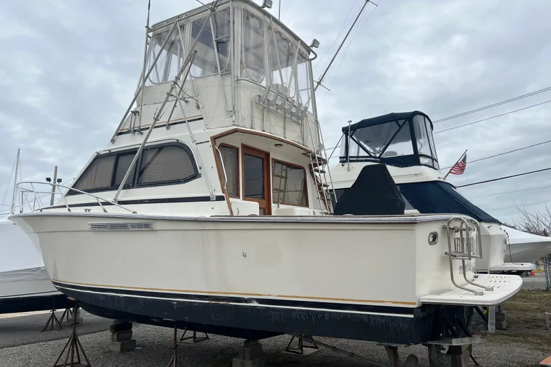 Slide: The Image of 1989 Egg Harbor 35 Sport Fisherman boat on stands, cloudy sky background. - 34