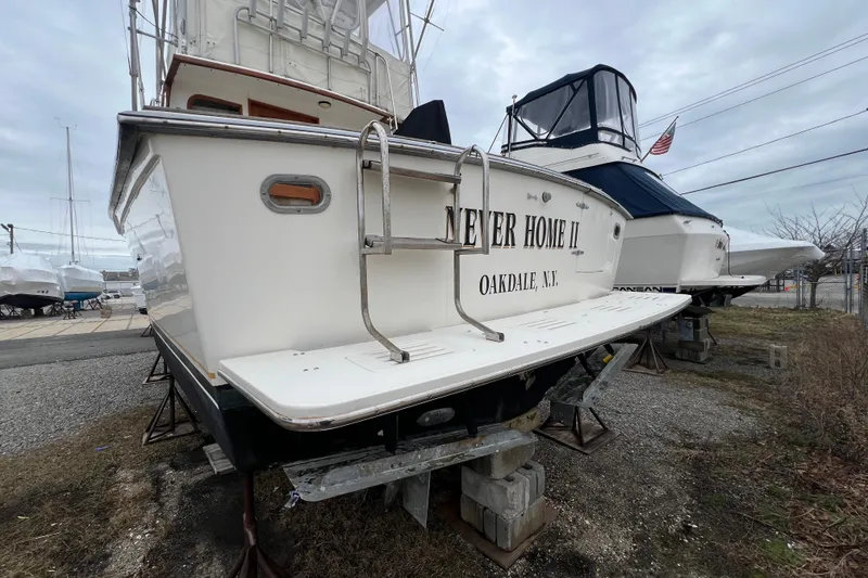 Slide: The Image of 1989 Egg Harbor 35 Sport Fisherman boat on dry dock, rear view with ladder. - 35