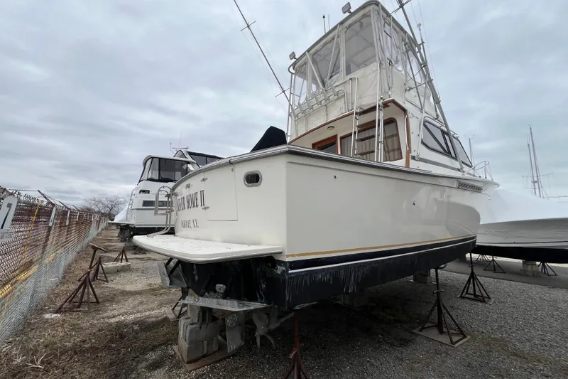 Slide: The Image of 1989 Egg Harbor 35 Sport Fisherman boat on stands, overcast sky background. - 36