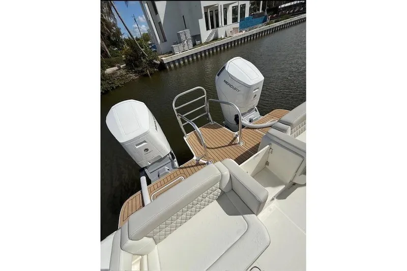 Slide: The Image of World Cat 400 DC-X Island 2026 boat with dual Mercury outboard engines on a calm waterway. - 18