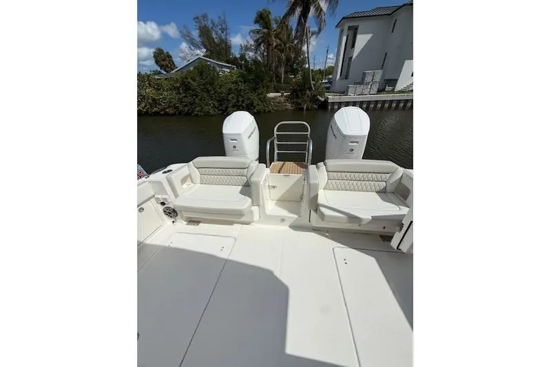 Slide: The Image of 2026 World Cat 400 DC-X Island boat with dual engines and seating, docked by a canal. - 19