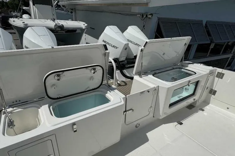 Slide: The Image of 2026 World Cat 400 DC-X Island boat with open storage compartments and Mercury engines. - 29