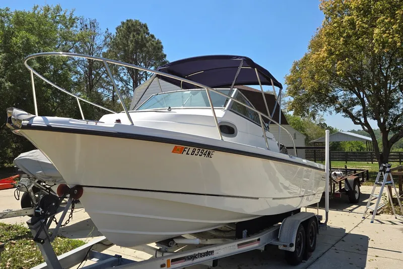 The Image of 2006 Boston Whaler 205 Conquest boat on trailer under blue sky. - 0