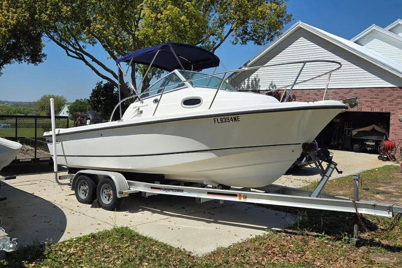 Slide: The Image of 2006 Boston Whaler 205 Conquest boat on trailer under cloudy sky. - 1